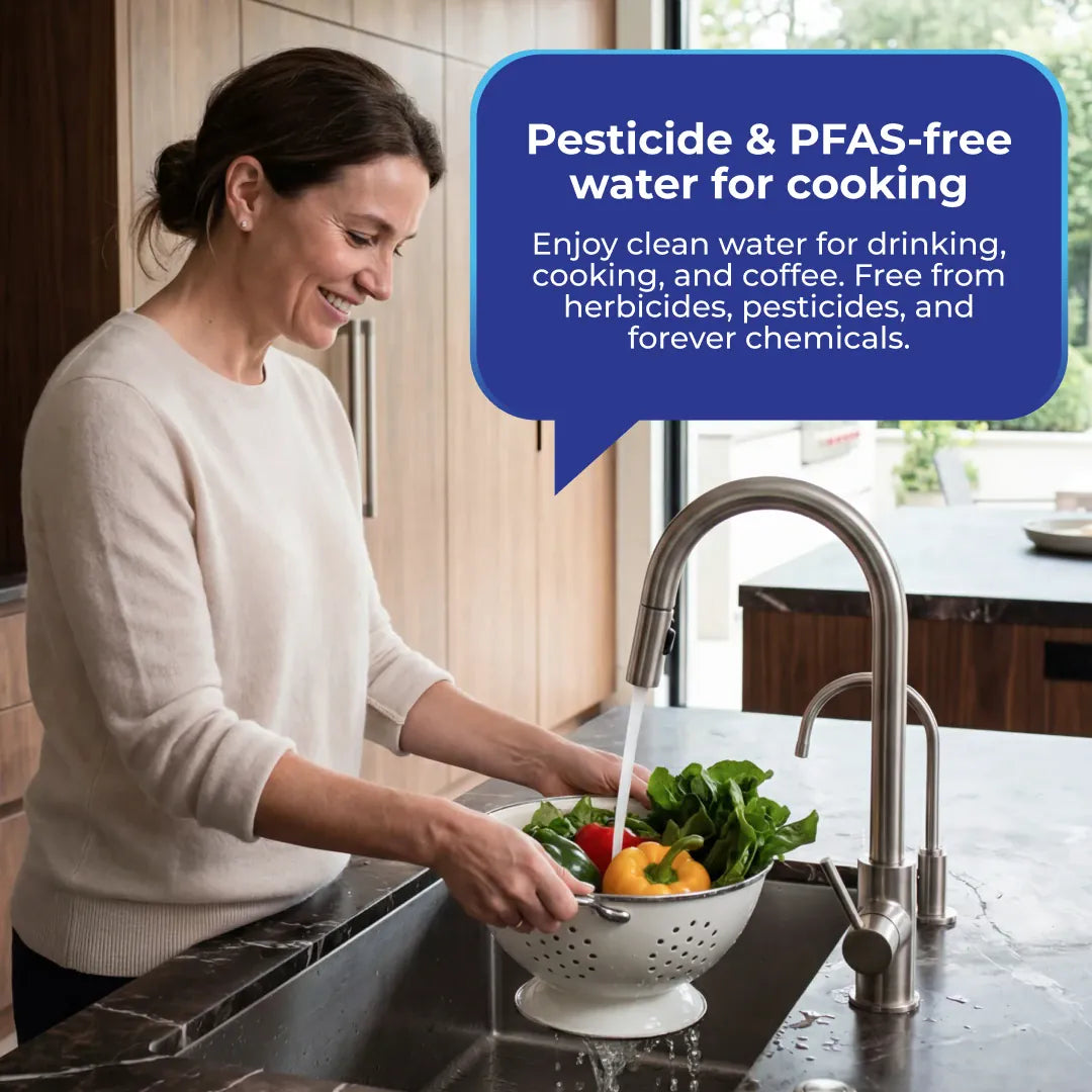 Woman washing vegetables in a white colander under a metal faucet in a kitchen sink with a blue text bubble overlay.