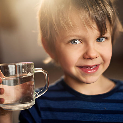 Boy Smiling holding  glass of water