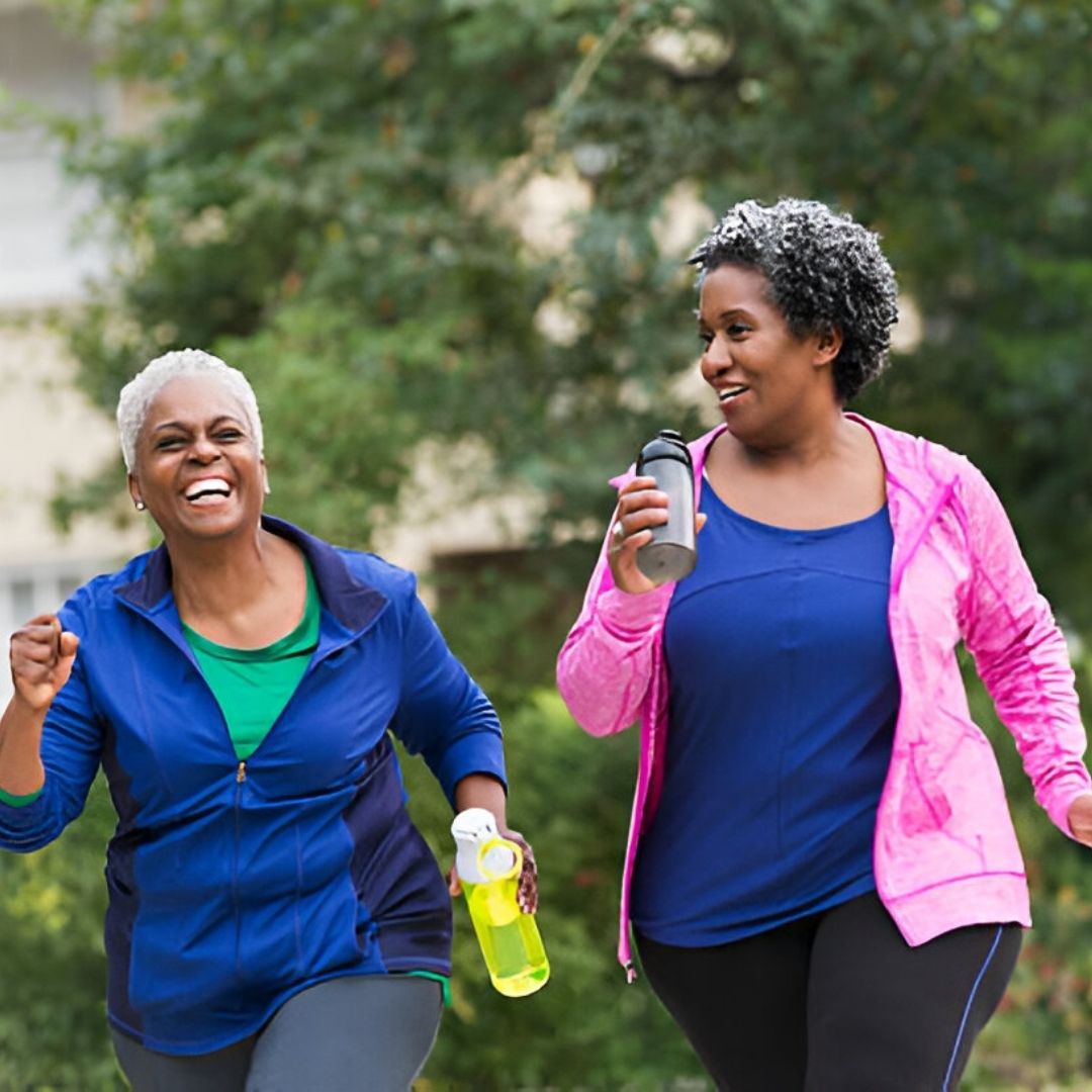 Two African American women walking and smiling with water bottles