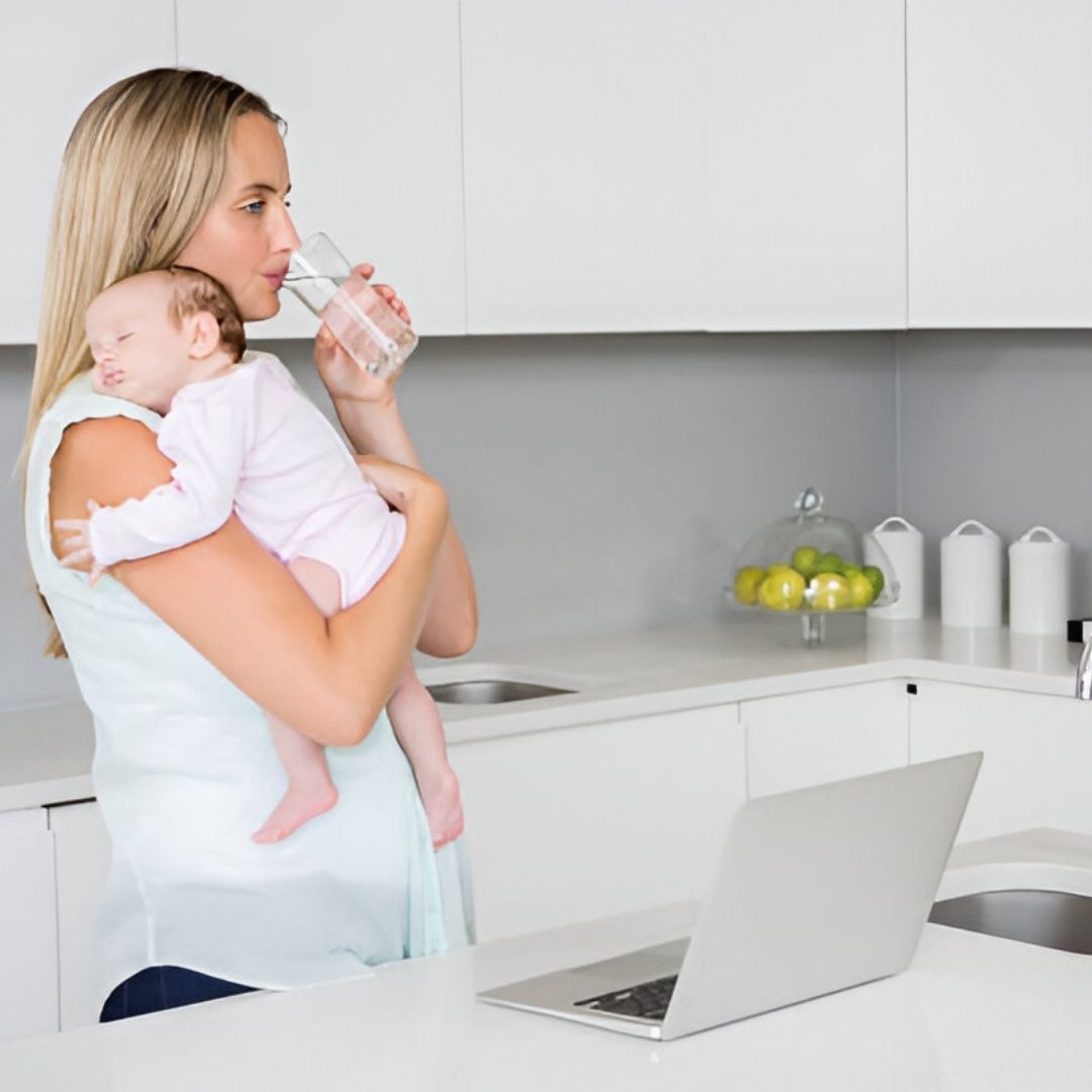 Mom Holding Baby Drinking Water In Kitchen Laptop - SoftPro Water Filters and Purification