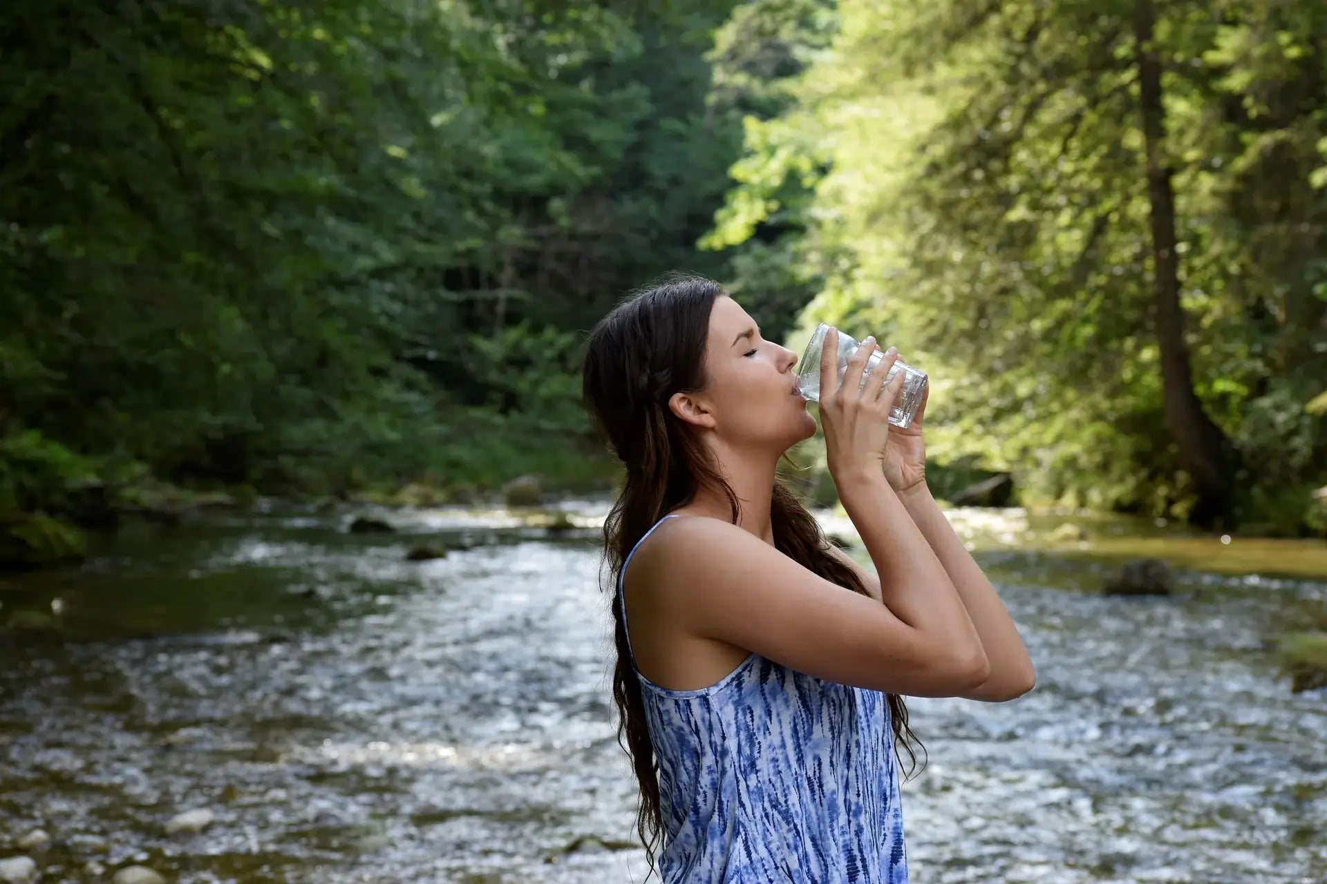 Woman drinking healthy water Near River.webp__PID:608cafe7-ba1e-41a9-a6b3-d5ddfd9b11ce
