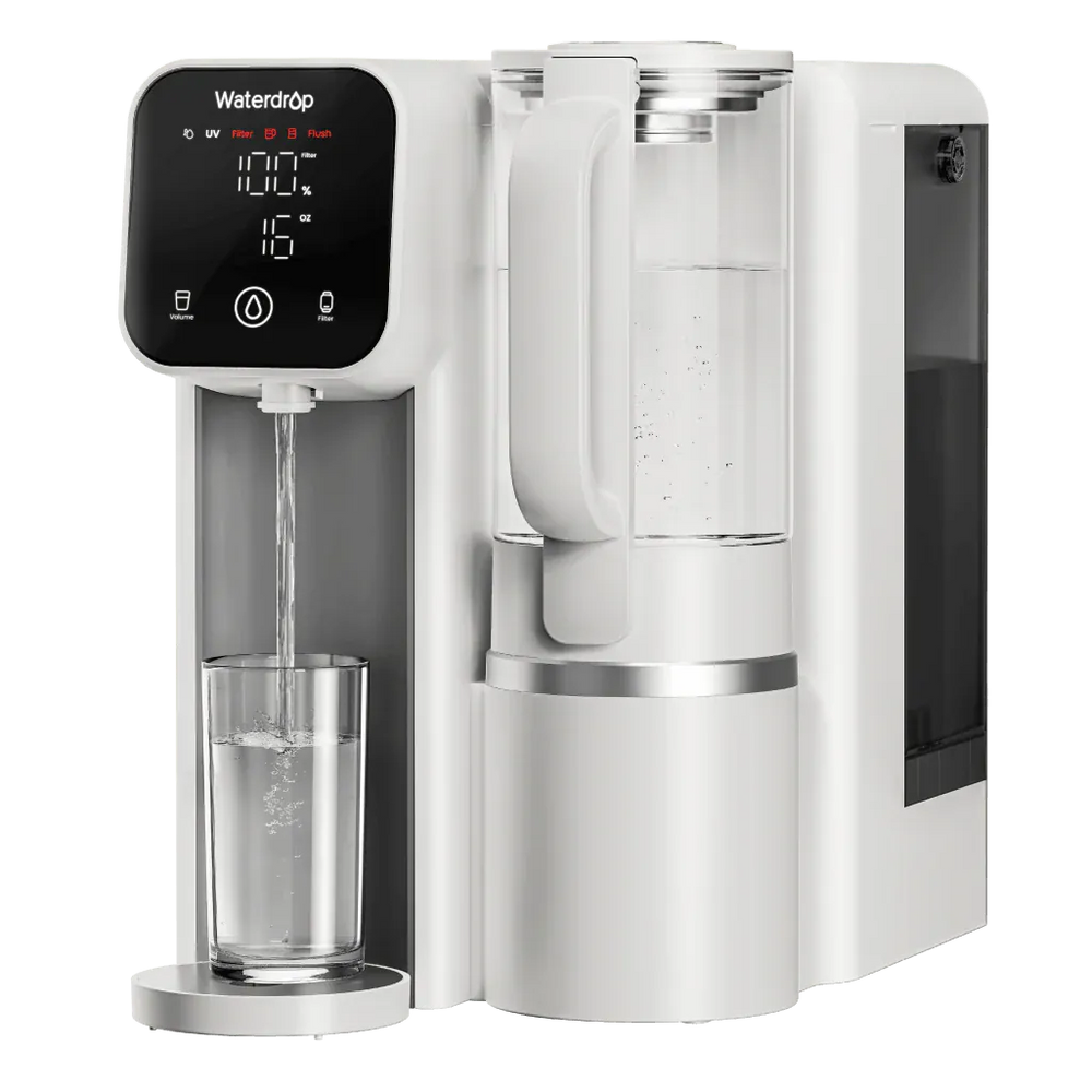 White plastic Waterdrop countertop filter dispensing water into a glass, featuring a digital display and glass carafe.