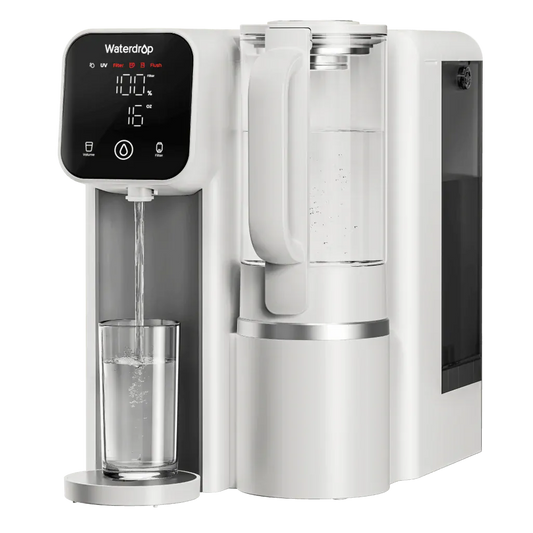White plastic Waterdrop countertop filter dispensing water into a glass, featuring a digital display and glass carafe.